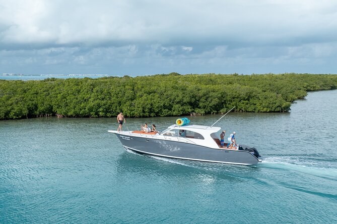 A motor yacht running past a mangrove shore
